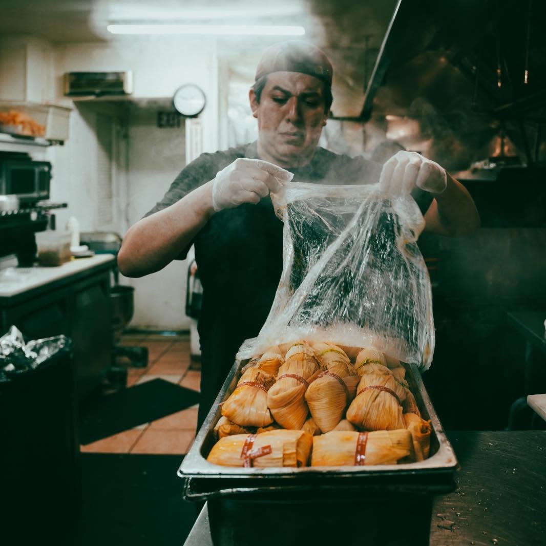 Isrrael Veliz preparando tamales en la cocina de City Tamale